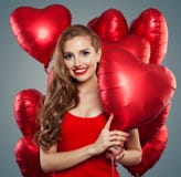 Femme heureuse tenant le coeur rouge de ballons Surprise, valentines les gens et concept de Saint-Valentin Maquillage rouge de lè photographie stock libre de droits Femme heureuse tenant le coeur rouge de ballons Surprise, valentines les gens et concept de Saint-Valentin Maquillage rouge de lè photographie stock libre de droits