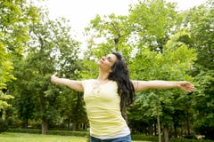 Femme latine attirante heureuse jetant ses mains dans la détente d'air photos libres de droits Femme latine attirante heureuse jetant ses mains dans la détente d'air photos libres de droits