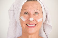 Femme mûre avec la protection solaire sur le visage Image stock Femme mûre avec la protection solaire sur le visage Image stock