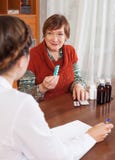 Femme mûre portant plainte au docteur au sujet des symptômes photographie stock libre de droits Femme mûre portant plainte au docteur au sujet des symptômes photographie stock libre de droits