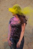 Femme magnifique de brune appréciant le festival de Holi au désert Femme posant avec éclater la peinture jaune images stock Femme magnifique de brune appréciant le festival de Holi au désert Femme posant avec éclater la peinture jaune images stock