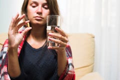 Femme malade tenant la pilule et le verre de l'eau image stock Femme malade tenant la pilule et le verre de l'eau image stock