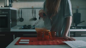 Femme maladroite de brune versant le jus d'orange dans le verre rouge, flaques il partout banque de vidéos Femme maladroite de brune versant le jus d'orange dans le verre rouge, flaques il partout banque de vidéos