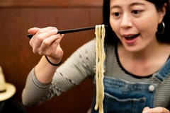 Femme mangeant de l'udon japonais dans une boutique photographie stock Femme mangeant de l'udon japonais dans une boutique photographie stock