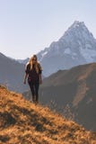Femme marchant dans la seule aventure de voyage de montagnes photos stock Femme marchant dans la seule aventure de voyage de montagnes photos stock