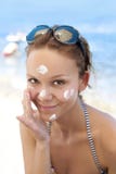 Femme mettant la protection solaire photo stock Femme mettant la protection solaire photo stock