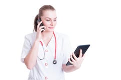 Femme occupée de docteur à l'aide du smartphone et du comprimé sans fil photo libre de droits Femme occupée de docteur à l'aide du smartphone et du comprimé sans fil photo libre de droits