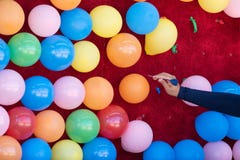Femme sautant les ballons colorés avec un dard photo stock Femme sautant les ballons colorés avec un dard photo stock