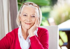 Femme supérieure de sourire s'asseyant à la maison de repos photos libres de droits Femme supérieure de sourire s'asseyant à la maison de repos photos libres de droits