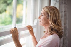 Femme supérieure réfléchie regardant de la fenêtre Images libres de droits Femme supérieure réfléchie regardant de la fenêtre Images libres de droits