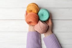 Femme tenant des boucles des fils sur le fond en bois photos stock Femme tenant des boucles des fils sur le fond en bois photos stock