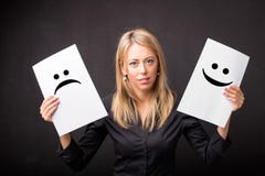 Femme tenant des feuilles avec des smiley tristes et heureux photo libre de droits Femme tenant des feuilles avec des smiley tristes et heureux photo libre de droits