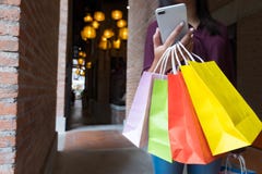 Femme tenant le sac à provisions et à l'aide du smartphone pour faire des emplettes concept en ligne et faisant des emplettes images stock Femme tenant le sac à provisions et à l'aide du smartphone pour faire des emplettes concept en ligne et faisant des emplettes images stock