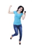 Femme tenant le téléphone portable et sauter photo libre de droits Femme tenant le téléphone portable et sauter photo libre de droits