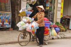 Femme vendant des balais et des objets de plastique photographie stock Femme vendant des balais et des objets de plastique photographie stock