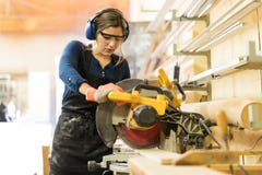 Femme à l'aide des machines-outils dans un woodshop photographie stock Femme à l'aide des machines-outils dans un woodshop photographie stock