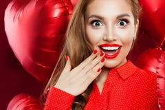 Femme étonnée avec le maquillage rouge de lèvres et main manicured sur le fond rouge de ballons de coeur Visage enthousiaste de p images libres de droits Femme étonnée avec le maquillage rouge de lèvres et main manicured sur le fond rouge de ballons de coeur Visage enthousiaste de p images libres de droits