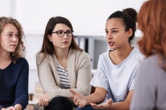 Femmes se soutenant au cours de la r?union de groupe de psychoth?rapie photographie stock Femmes se soutenant au cours de la r?union de groupe de psychoth?rapie photographie stock