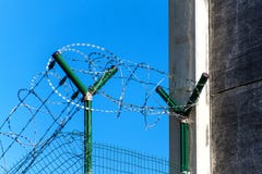 Fence with razor barbed wire. Guarded area. Military base. Razor wire. Stock Photo Fence with razor barbed wire. Guarded area. Military base. Razor wire. Stock Photo