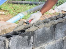 Fermez-vous d'installer des briques dans le chantier de construction par le maçon industriel images stock Fermez-vous d'installer des briques dans le chantier de construction par le maçon industriel images stock