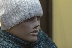 Fermez-vous d'un mannequin factice de femme avec une bande de premiers secours sur le nez, le chapeau tissé et l'écharpe Vue de p photos libres de droits Fermez-vous d'un mannequin factice de femme avec une bande de premiers secours sur le nez, le chapeau tissé et l'écharpe Vue de p photos libres de droits