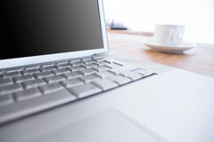 Fermez-vous de l'ordinateur portable et du café sur un bureau image libre de droits Fermez-vous de l'ordinateur portable et du café sur un bureau image libre de droits