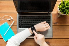 Fermez-vous de la femme avec la montre et l'ordinateur portable intelligents photo stock Fermez-vous de la femme avec la montre et l'ordinateur portable intelligents photo stock