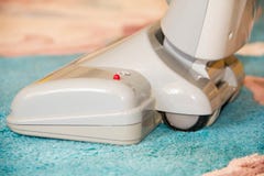 Fermez-vous de la tête d'un aspirateur moderne étant employé tout en nettoyant à l'aspirateur un tapis épais de blanc de pile photos stock Fermez-vous de la tête d'un aspirateur moderne étant employé tout en nettoyant à l'aspirateur un tapis épais de blanc de pile photos stock