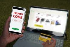 Fermez-vous des mains masculines tenant le smartphone avec le code rouge de promo de mots écrits sur l'écran et la carte de crédi image libre de droits Fermez-vous des mains masculines tenant le smartphone avec le code rouge de promo de mots écrits sur l'écran et la carte de crédi image libre de droits