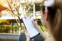 Fermez-vous des mains signant le contrat de bail du jour ensoleillé de femme, le fond d'appartement, foyer sur le Doc. Avant util images libres de droits Fermez-vous des mains signant le contrat de bail du jour ensoleillé de femme, le fond d'appartement, foyer sur le Doc. Avant util images libres de droits