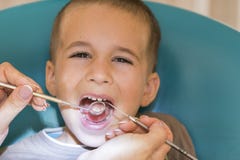 Fermez-vous du garçon faisant examiner ses dents par un garçon beau du dentiste A à l'hygiène d'Oral de dentiste photographie stock libre de droits Fermez-vous du garçon faisant examiner ses dents par un garçon beau du dentiste A à l'hygiène d'Oral de dentiste photographie stock libre de droits