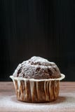 Fermez-vous du petit pain délicieux de chocolat sur une table en bois, sur le fond noir, avec la neige comme le sucre de poudre d images stock Fermez-vous du petit pain délicieux de chocolat sur une table en bois, sur le fond noir, avec la neige comme le sucre de poudre d images stock