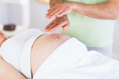 Fermez-vous vers le haut de la vue de la femme enceinte obtenant le traitement de reiki photographie stock libre de droits Fermez-vous vers le haut de la vue de la femme enceinte obtenant le traitement de reiki photographie stock libre de droits