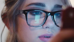 Fermez-vous vers le haut de la vue de la fille assez aux yeux bleus de jeunes en verres de vintage attentivement utilisant son té banque de vidéos Fermez-vous vers le haut de la vue de la fille assez aux yeux bleus de jeunes en verres de vintage attentivement utilisant son té banque de vidéos