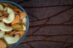 Fermez-vous vers le haut de la vue supérieure des raisins secs nuts d'amandes d'anarcadier dans une cuvette sur la table en bois photos stock Fermez-vous vers le haut de la vue supérieure des raisins secs nuts d'amandes d'anarcadier dans une cuvette sur la table en bois photos stock