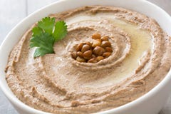 Fermez-vous vers le haut du houmous de lentille dans la cuvette sur le bois image stock Fermez-vous vers le haut du houmous de lentille dans la cuvette sur le bois image stock