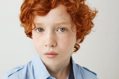 Fermez-vous vers le haut du portrait du petit enfant drôle avec les cheveux et les taches de rousseur oranges Garçon regardant in Photo stock Fermez-vous vers le haut du portrait du petit enfant drôle avec les cheveux et les taches de rousseur oranges Garçon regardant in Photo stock