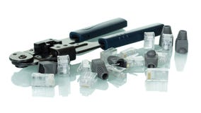 Ferramenta de friso para o cabo da rede do twisted pair com os conectores e os tampões isolados no branco fotografia de stock Ferramenta de friso para o cabo da rede do twisted pair com os conectores e os tampões isolados no branco fotografia de stock