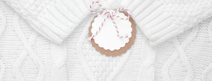 Festive white knitted winter sweater with a label for congratulations. Winter holidays. Banner stock image Festive white knitted winter sweater with a label for congratulations. Winter holidays. Banner stock image