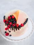 Festlicher Kuchen mit schmelzender Schokolade und sortierten Früchten in einem Waffelhorn auf neutralem Hintergrund stockfoto Festlicher Kuchen mit schmelzender Schokolade und sortierten Früchten in einem Waffelhorn auf neutralem Hintergrund stockfoto