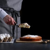 Fette del cuoco unico una torta su fondo scuro torta che fa concetto ricetta della torta o del dolce fotografia stock Fette del cuoco unico una torta su fondo scuro torta che fa concetto ricetta della torta o del dolce fotografia stock