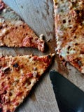 Fette della pizza su un piatto di legno fotografia stock Fette della pizza su un piatto di legno fotografia stock