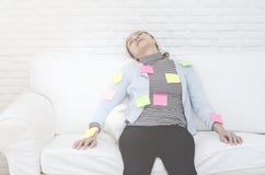 Feuilles de papier jaunes, vertes et roses sur la femme qui dort et épuisé du travail image libre de droits Feuilles de papier jaunes, vertes et roses sur la femme qui dort et épuisé du travail image libre de droits