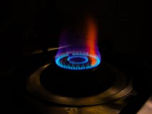 Fiamma blu isolata con tonalità arancio del bruciatore a gas a fondo nero immagine stock libera da diritti Fiamma blu isolata con tonalità arancio del bruciatore a gas a fondo nero immagine stock libera da diritti