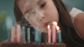 Fiamma di candela di salto della ragazza graziosa sulla torta di compleanno al rallentatore Buon compleanno stock footage Fiamma di candela di salto della ragazza graziosa sulla torta di compleanno al rallentatore Buon compleanno stock footage