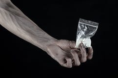 The fight against drugs and drug addiction topic: dirty hand holding a bag addict cocaine on a black background in the studio Stock Image The fight against drugs and drug addiction topic: dirty hand holding a bag addict cocaine on a black background in the studio Stock Image