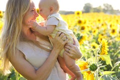 Figlia felice del bambino e della madre nel giacimento del girasole fotografie stock Figlia felice del bambino e della madre nel giacimento del girasole fotografie stock