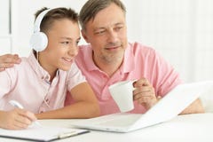 Figlio e padre che per mezzo del computer portatile Immagine Stock Figlio e padre che per mezzo del computer portatile Immagine Stock