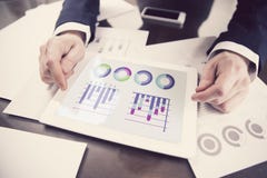 Figure di vendite concetto, uomo d'affari che lavora con la compressa digitale all'ufficio immagine stock libera da diritti Figure di vendite concetto, uomo d'affari che lavora con la compressa digitale all'ufficio immagine stock libera da diritti
