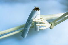 Figure squelettique cassant une cigarette Mises ? mort de tabagisme photographie stock Figure squelettique cassant une cigarette Mises ? mort de tabagisme photographie stock